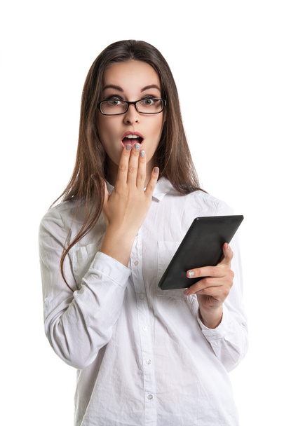 Красивая молодая длинноволосая женщина в очках с электронной книгой. Человеческие эмоции, удивление, рот открыт
 - Фото, изображение