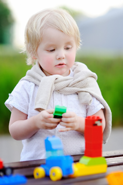 Toddler boy playing with colorful plastic blocks - Photo, Image