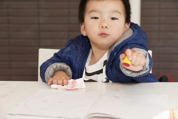 a cute baby is painting on the table - Photo, Image