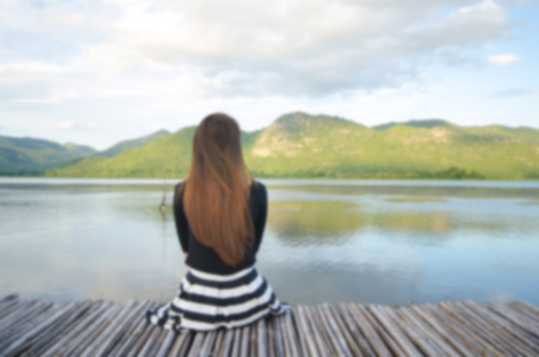 blurred background of alone girl on pier  - Photo, Image