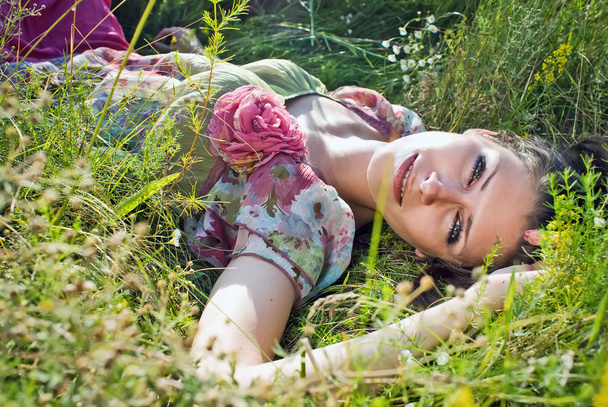 Cute young female lying on grass field at the park - Foto, Imagem
