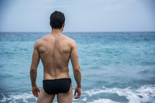 Back view of man in trunks against of seascape - Foto, afbeelding