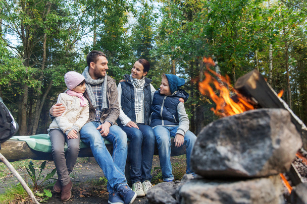 happy family sitting on bench at camp fire - Zdjęcie, obraz