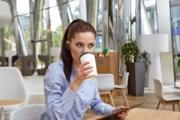 woman with touch-pad and sitting in cafe - Foto, Bild