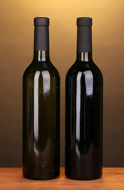Bottles of great wine on wooden table on brown background - Fotoğraf, Görsel