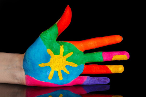 Brightly colored hand on black background close-up - Фото, изображение