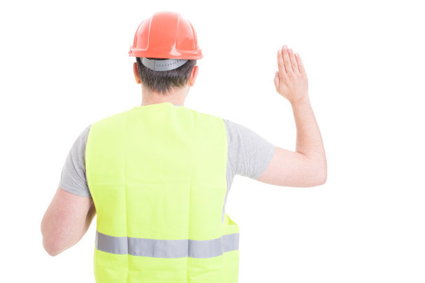Back view of male constructor standing and doing a vow  - Foto, Imagem