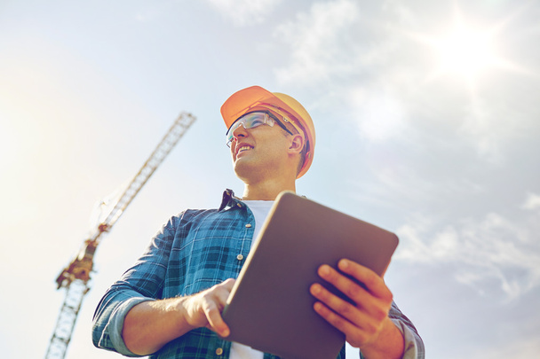 builder in hardhat with tablet pc at construction - Photo, image