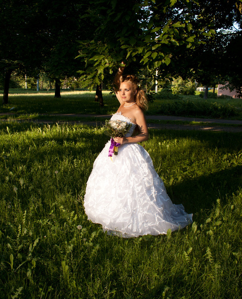 Beautiful girl in a wedding dress with bouquet - Fotoğraf, Görsel
