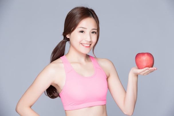 Sport girl with an apple smiling - Valokuva, kuva