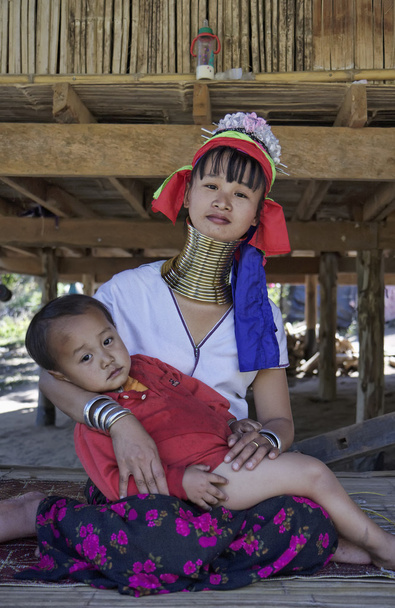 Thailand, Chang Mai, Karen Long Neck hill tribe village (Kayan Lahwi), Long Neck child and his mother in traditional costumes. Women put brass rings on their neck when they are 5 or 6 years old and in - Photo, Image