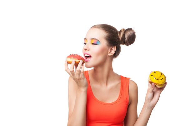 Studio shot of young brunette biting donut - Photo, Image