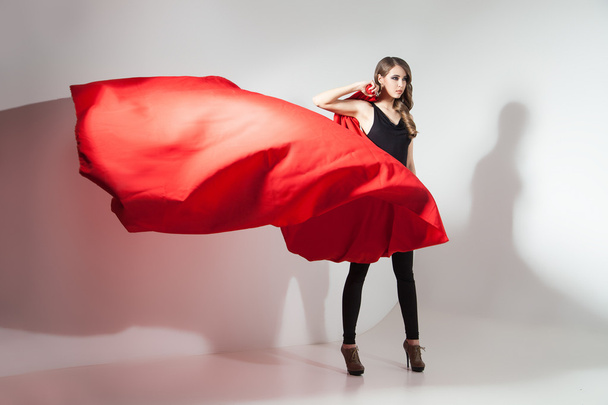 Side view of young woman with waving red cloth - Foto, Bild