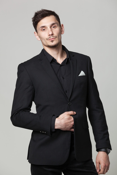 Studio portrait of handsome elegant young man in black  clothes  - 写真・画像