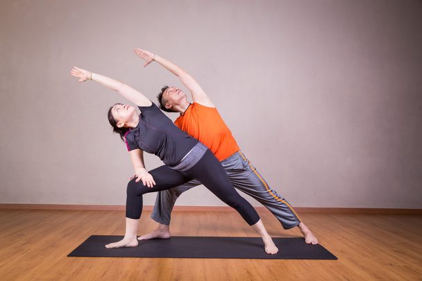 Pareja realizar serie de Extended Side Angle yoga pareja pose
 - Foto, Imagen