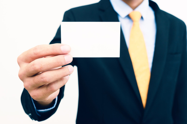 Empresário segurando e mostrando cartão de visita em branco isolado no fundo branco
. - Foto, Imagem