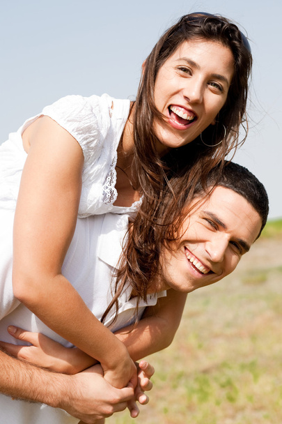 mosolygó fiatal pár piggybacking - Fotó, kép