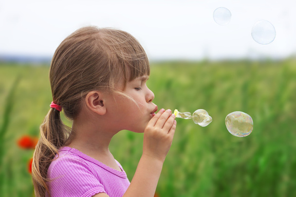 Portrait de mignonne jolie petite fille soufflant des bulles de savon
 - Photo, image