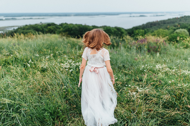 beautiful girl in white dress lies in green grass - Fotoğraf, Görsel