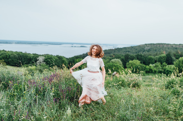 hermosa chica en vestido blanco se encuentra en la hierba verde
 - Foto, imagen
