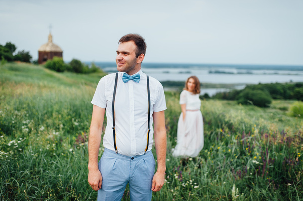 Happy Bride and groom walking on the green grass - Фото, зображення