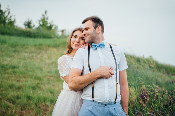 glückliche Braut und Bräutigam auf dem grünen Gras - Foto, Bild