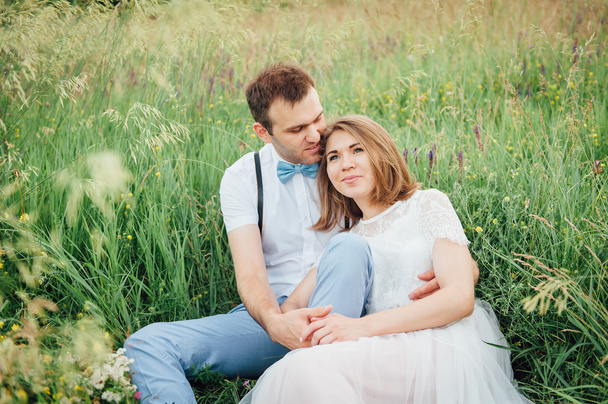 glückliche Braut und Bräutigam auf dem grünen Gras - Foto, Bild