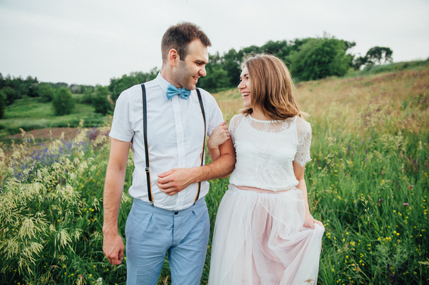 Feliz novia y novio caminando sobre la hierba verde
 - Foto, Imagen