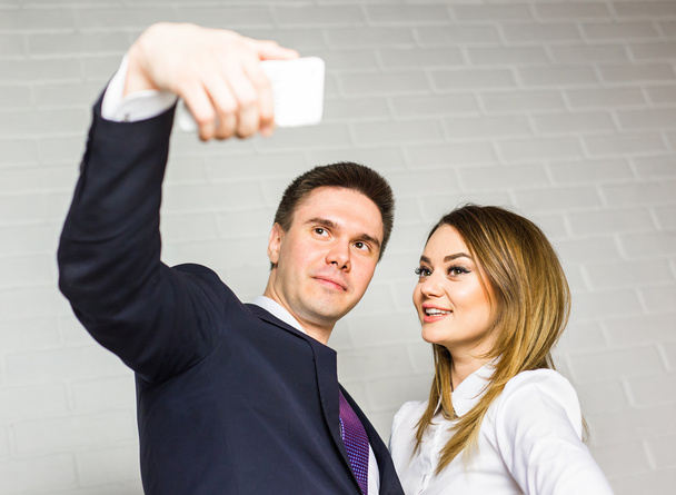 Dos empresarios exitosos tomando un selfie feliz en la oficina
. - Foto, imagen