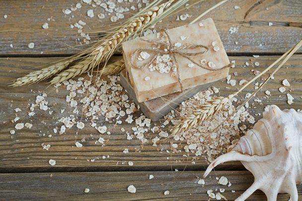 Natural handmade soap, oat flakes and wheat ears on wooden backg - Fotoğraf, Görsel