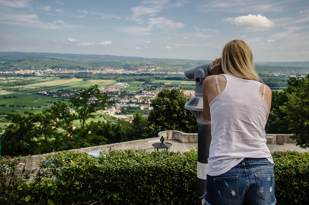 Blonde fille à la recherche à travers un télescope touristique en Autriche
. - Photo, image