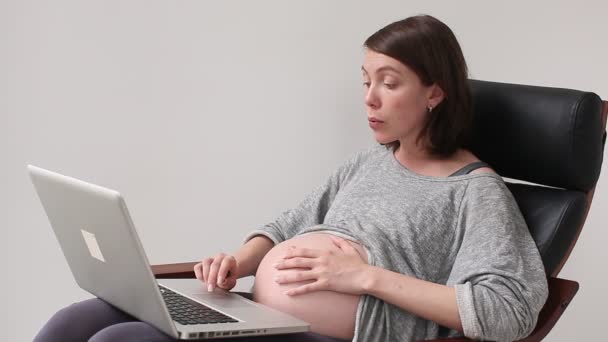 Kobieta w ciąży za pomocą laptopa dla rozwiązuje problem - Materiał filmowy, wideo
