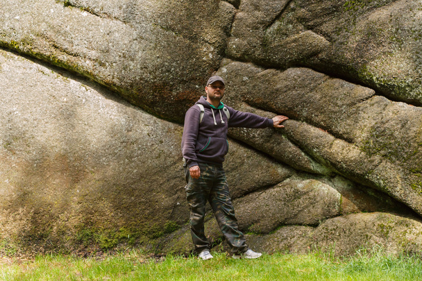 homem de pé debaixo de uma rocha
 - Foto, Imagem