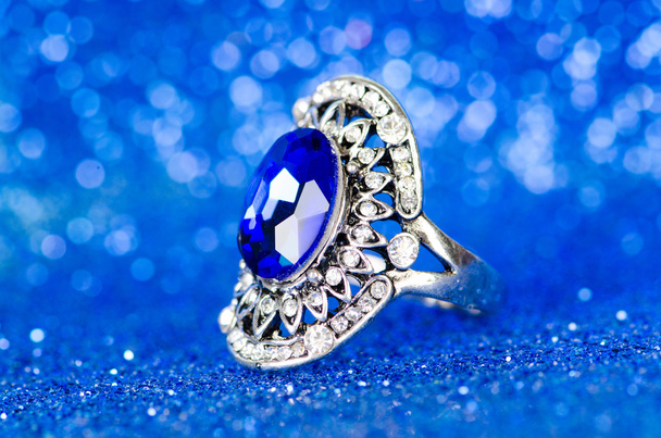 Sieraden ring tegen blauwe achtergrond - Foto, afbeelding