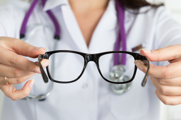 Female oculist doctor hands giving pair of glasses. Good vision  - Photo, Image
