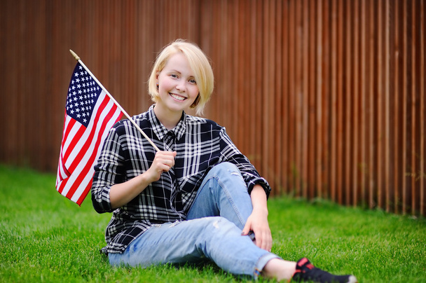 Happy young woman holding american flag - Foto, imagen