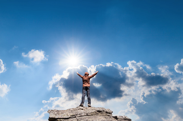 Man standing on the top of the mountain over blue sunny sky - Foto, afbeelding