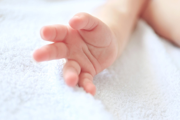 Baby hand on white sheet - Valokuva, kuva