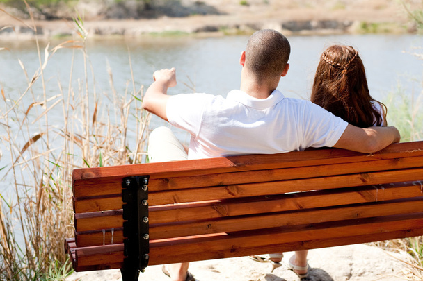 Jeune couple assis sur le banc en bois
 - Photo, image