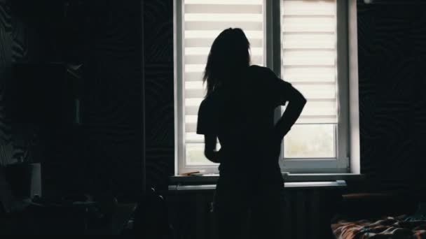 siluetti tyttö tanssii ikkunan edessä kotona
 - Materiaali, video