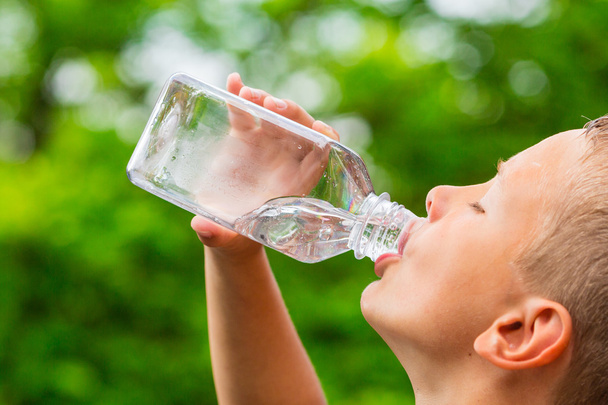 Jeune garçon boire de l'eau de bouteille
 - Photo, image