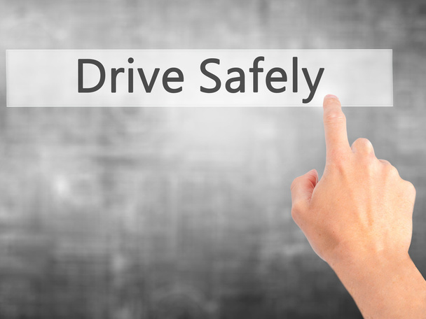 Conduce con seguridad - Mano presionando un botón en el cono de fondo borroso
 - Foto, imagen