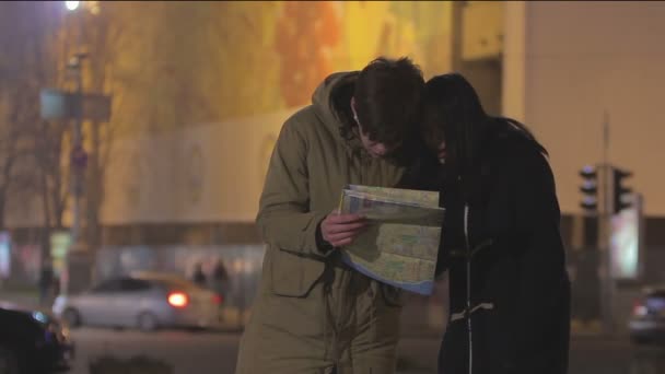 Young people travel abroad, lost in megalopolis, searching right way on city map - Footage, Video