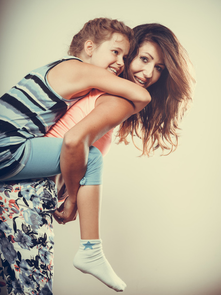 Moeder ouder geven kind piggyback rit. - Foto, afbeelding