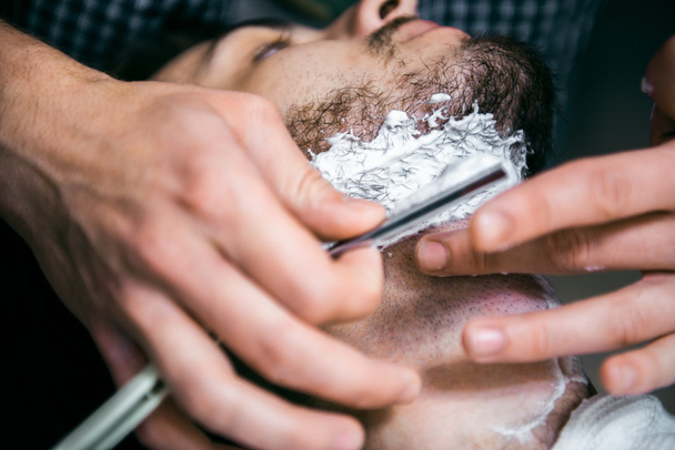 Le coiffeur coupe la barbe.
. - Photo, image
