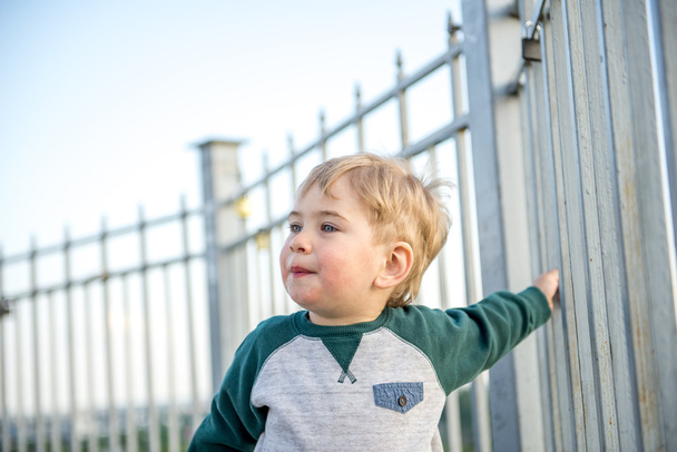 petit garçon grimpé sur la clôture
 - Photo, image