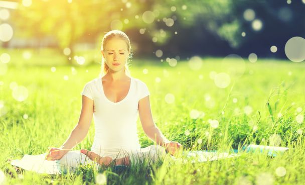 mujer joven disfrutando de la meditación y el yoga sobre hierba verde en resumen
 - Foto, Imagen