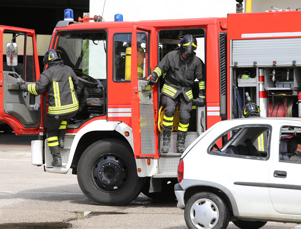 Bomberos descienden rápidamente de camión de bomberos
 - Foto, Imagen