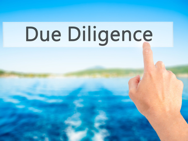 Due Diligence - Hand pressing a button on blurred background con - Photo, Image