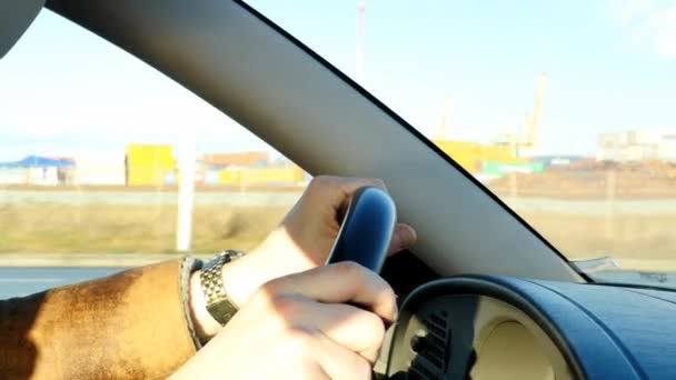 Auto bestuurder rijden een auto close-up met de achtergrond van industriële weergave - Video